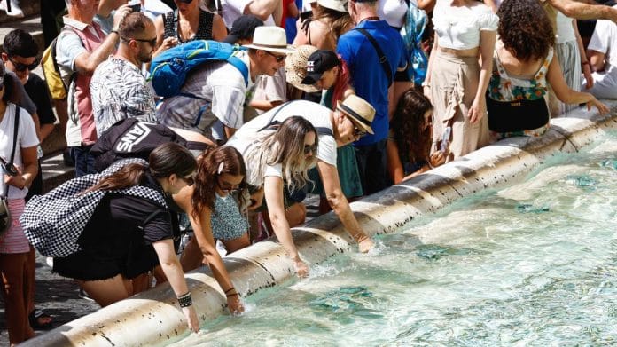 People cool themselves at the Trevi Fountain during a heatwave across Italy as temperatures are expected to cool off in Rome, on 20 July 2023 | Reuters