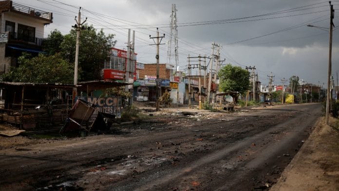 A burnt shop is seen next to a deserted road during a curfew imposed by the authorities following clashes between Hindus and Muslims in Nuh district of the northern state of Haryana, India | Reuters