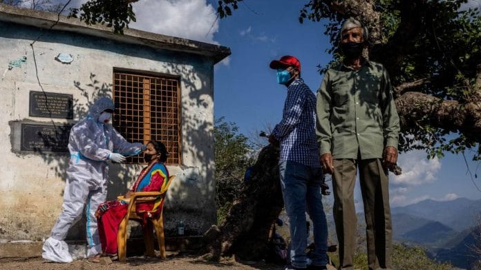 A healthcare worker wearing personal protective equipment (PPE), collects a swab sample from a woman to test her for COVID-19, during the the coronavirus disease (COVID-19) outbreak, at Pitha village in the northern state of Uttarakhand, India | Reuters