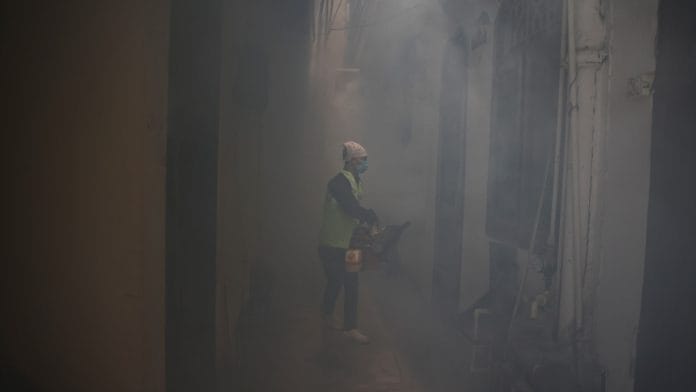 A health worker fumigates interiors of a house in a residential neighbourhood to prevent the spread of mosquito-borne diseases following the rise in dengue cases in New Delhi, India | Reuters