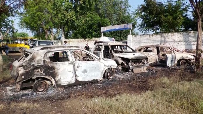 Damaged vehicles lie on the road in the aftermath of a clashes in Haryana's Nuh | Photo: ANI
