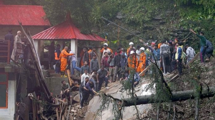 Rescue workers remove the debris as they search for survivors after a landslide following torrential rain in Shimla, on 14 August 2023 | Reuters