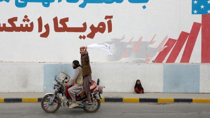 A Taliban supporter holds an Islamic Emirate of Afghanistan flag on the first anniversary of the fall of Kabul on a street in Kabul, Afghanistan, August 15, 2022 | Reuters