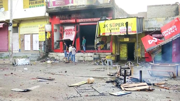 People stand outside a shop after a clash erupted between two groups in Haryana's Nuh, on 31 July 2023 | ANI photo