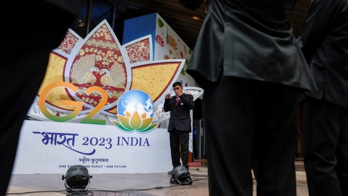 Indian security pose for selfies in front of a G20 sign outside the International Media Center during the G20 Summit in New Delhi, India | Reuters