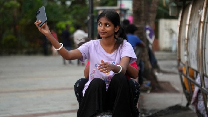 Maleesha Kharwa, 15, a model and Instagram Influencer, takes a selfie next to a bus terminal in Mumbai, India | Reuters