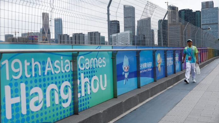 A person walks near a banner for the 19th Asian Games Hangzhou 2022, ahead of the games, in Hangzhou, Zhejiang province, China | Reuters