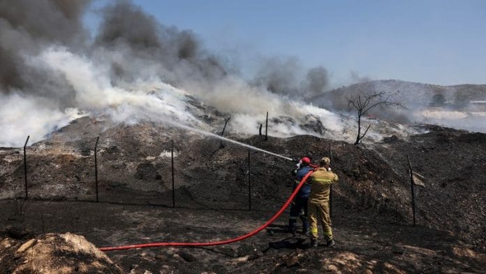 Firefighters try to extinguish a fire burning at a recycling plant, in Sesklo, in central Greece | Reuters
