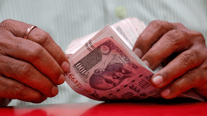 Representational photo of a man counting currency notes in Mumbai | Reuters/Francis Mascarenhas