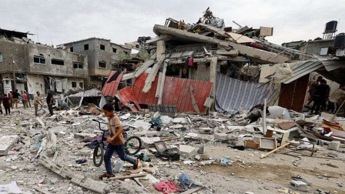 A child walks at the site of an Israeli air strike on a house in Khan Younis in the southern Gaza Strip, on 27 October 2023 | Reuters/Mohammed Salem