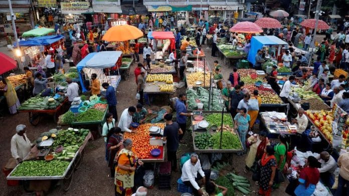 Customers buy fruits and vegetables at an open air evening market in Ahmedabad, India, August 21, 2023. REUTERS/Amit Dave/File photo