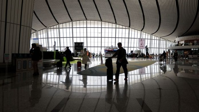 Travellers walk with their suitcases at Beijing Daxing International Airport in Beijing, China April 24, 2023 | REUTERS/Tingshu Wang/File photo