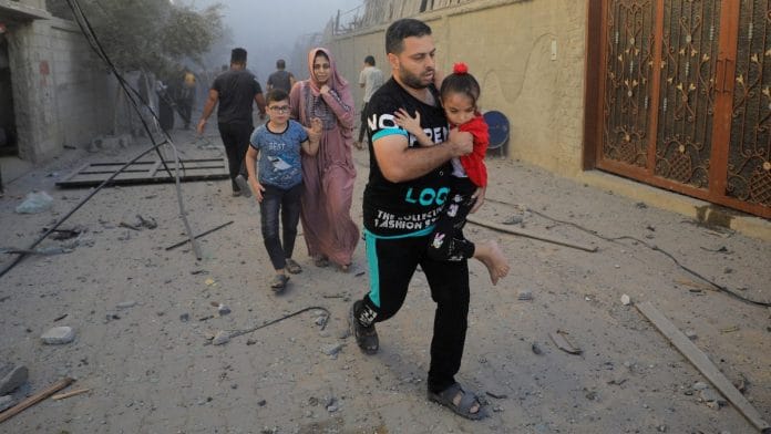 Palestinians evacuate the site of Israeli strikes on houses, amid the ongoing conflict between Israel and Palestinian Islamist group Hamas, in Maghazi refugee camp in the central Gaza Strip Monday I Reuters/Yasser Qudih