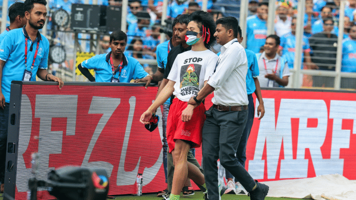 Security personnel escort the Palestine supporter who breached security to meet India's Virat Kohli during the ICC Men's Cricket World Cup 2023 final in Ahmedabad on Sunday | ANI