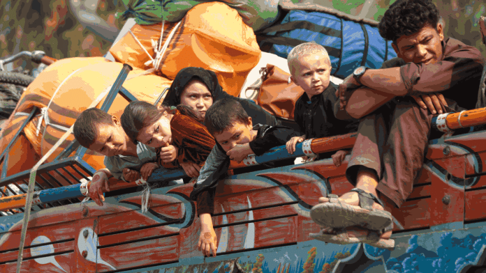 Afghan refugee children sit on a truck loaded with belongings as they their families prepare to return home, after Pakistan gives the last warning to undocumented immigrants to leave, outside the UNHCR repatriation centres in Azakhel town in Nowshera, Pakistan, 30 October | Reuters