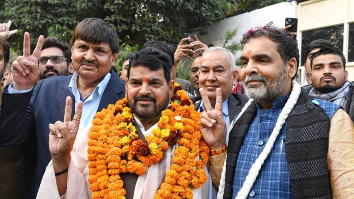BJP MP and former Wrestling Federation of India (WFI) president Brij Bhushan Sharan Singh with newly appointed WFI president Sanjay Singh show victory signs, at his residence in New Delhi on Thursday, 21 December | ANI
