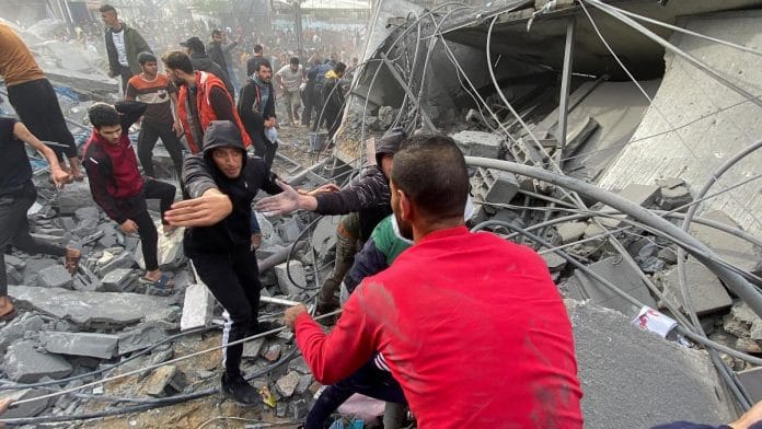 Palestinians search the site of an Israeli strike in Rafah, in the southern Gaza Strip, on 20 Dec 2023 | Reuters