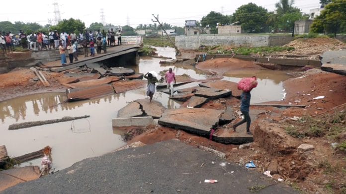 People cross through the collapsed bridge near Anthony Puram on the Thoothukudi-Madurai highway in Thoothukudi on Tuesday, 19 December | ANI