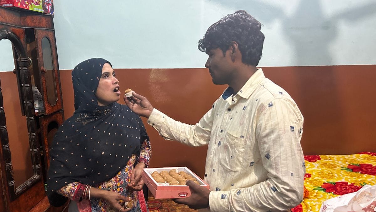 Naseem Malik offers sweets to his Sameena, who has been eagerly awaiting his return. Non-stop felicitations means he has barely had a chance to rest since he came home at 10 am on 30 November. | Jyoti Yadav | ThePrint