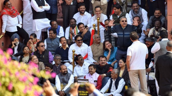 TMC MP Kalyan Banerjee mimics Rajya Sabha Chairman Jagdeep Dhankhar during a protest with suspended Opposition MPs at the Makar Dwar following the suspension of 92 MPs for the remainder of the ongoing winter session of Parliament, in New Delhi on Tuesday. Congress MP Rahul Gandhi also seen | ANI