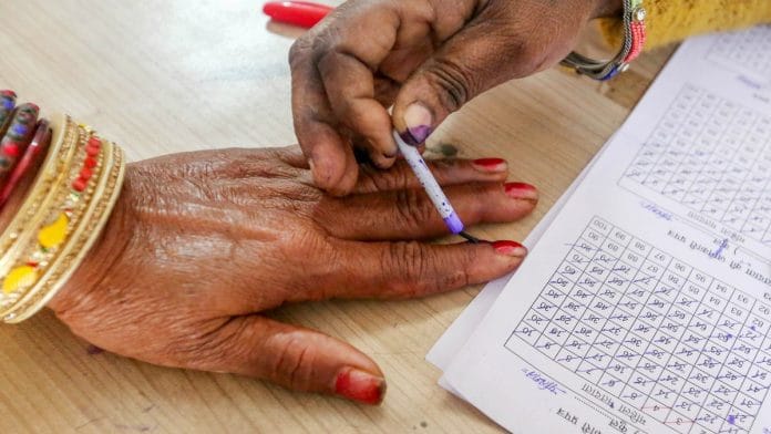 Polling official putting mark with indelible ink on finger of voter at polling booth in Bhopal on 17 Nov, 2023 | ANI