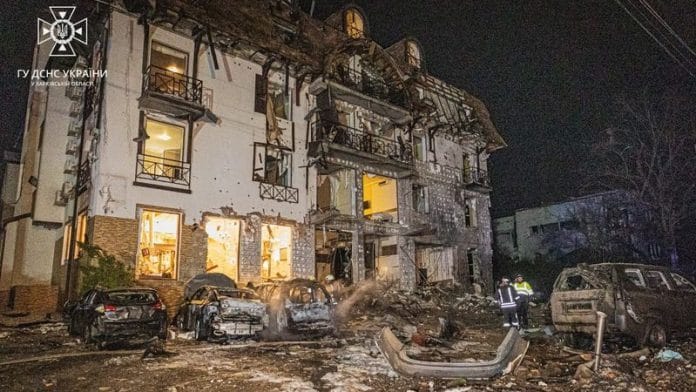 Rescuers stand at the site in the aftermath of a Russian missile strike on a hotel in Kharkiv, Ukraine, in this handout image released January 11, 2024. State Emergency Service of Ukraine/Handout via REUTERS