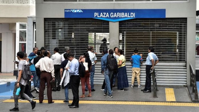 People stand outside the Plaza Garibaldi metro station closed following a violence outbreak a day after Ecuador's President Daniel Noboa declared a 60-day state of emergency following the disappearance of Adolfo Macias, leader of the Los Choneros criminal gang from the prison where he was serving a 34-year sentence, in Guayaquil, Ecuador, January 9, 2024. REUTERS/Vicente Gaibor del Pino