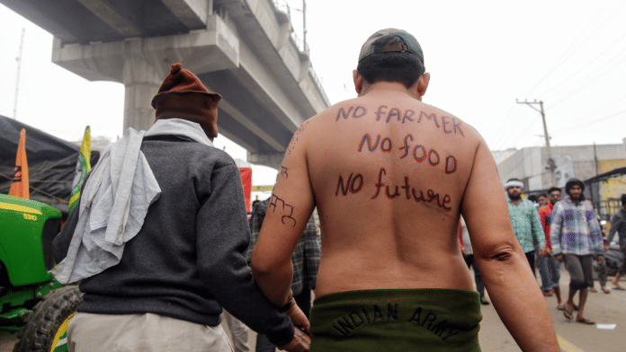 A farmer has slogans written on his back at Tikri Border in New Delhi | ANI