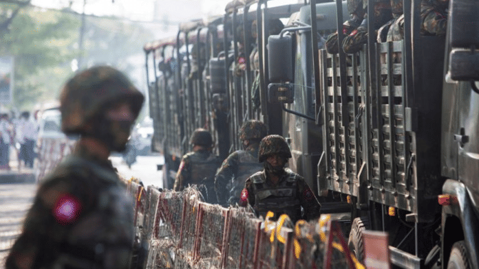 Soldiers stand next to military vehicles as people gather to protest against the military coup, in Yangon, Myanmar, February 15, 2021 | File Photo | Reuters