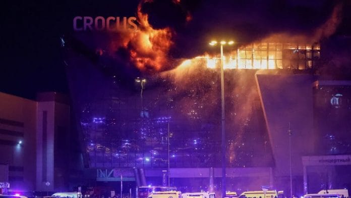 Ambulances and vehicles of Russian emergency services are parked outside the burning Crocus City Hall concert venue following a shooting incident, outside Moscow, Russia, March 22, 2024. REUTERS/Yulia Morozova