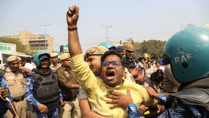 An AAP worker is detained by police at ITO junction in New Delhi on Friday | Suraj Bisht | ThePrint