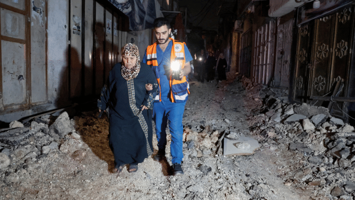 People walk in a damaged street after an Israeli raid at Nur Shams camp, Tulkarm, in the Israeli-occupied West Bank, 20 April 2024| Reuters/Raneen Sawafta