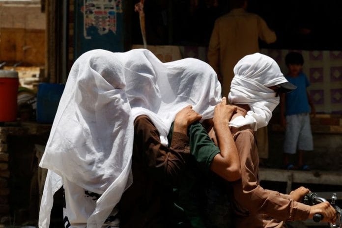 People covering their heads to combat heatwave in Pakistan.