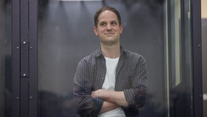 Wall Street Journal reporter Evan Gershkovich, who is in custody on espionage charges, stands behind a glass wall of an enclosure for defendants as he attends a court hearing in Moscow, Russia, April 23, 2024. REUTERS/Tatyana Makeyeva/File Photo
