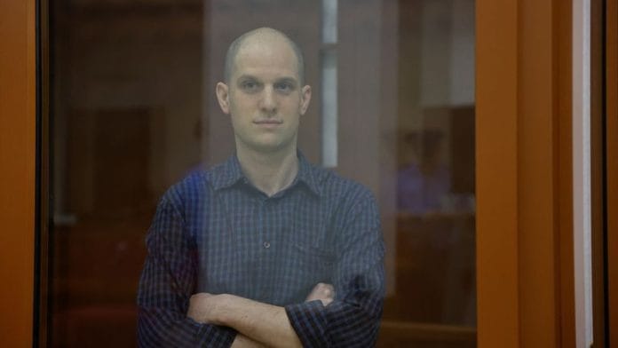Wall Street Journal reporter Evan Gershkovich, who faces charges of espionage, stands inside an enclosure for defendants as he attends a court hearing in Yekaterinburg, Russia July 19, 2024. REUTERS/Dmitry Chasovitin