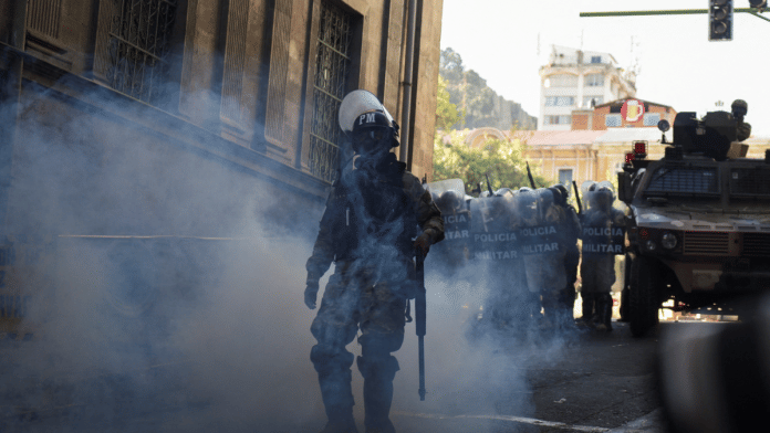 A member of the military police walks amid tear gas as Bolivia's President Arce 'denounced the irregular mobilization' of some units of the country's army, in La Paz, Bolivia on 26 June 2024 | Reuters | Claudia Morales