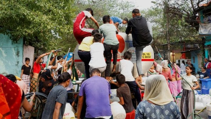 People rush to climb a water tanker as it arrives to deliver drinking water during the ongoing water crisis in New Delhi on Monday | REUTERS/Priyanshu Singh