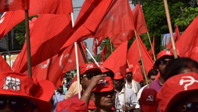 A CPI(M) rally with people wearing the party's caps and holding red flags.