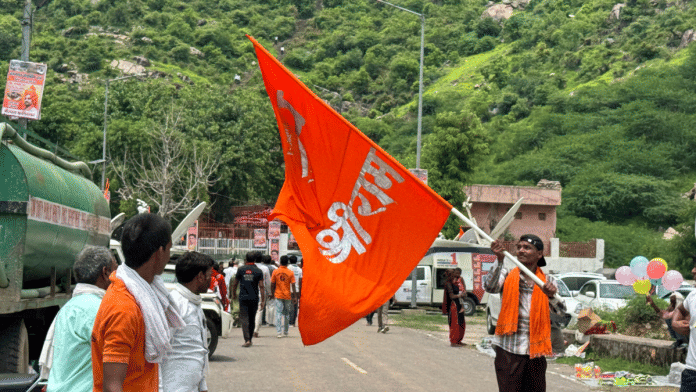 A man with a saffron flag outside the Shiva temple at Nalhar in Haryana on Monday | Sagrika Kissu | ThePrint