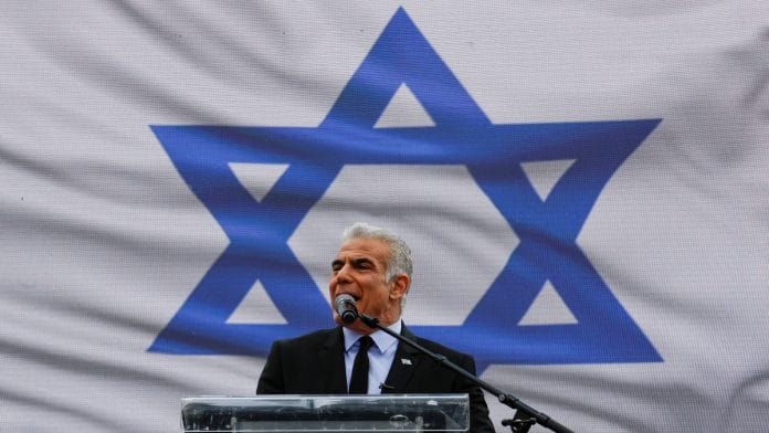Israel's opposition leader Yair Lapid addresses protesters at a demonstration after Israeli Prime Minister Benjamin Netanyahu dismissed the defense minister as his nationalist coalition government presses on with its judicial overhaul, in Jerusalem, March 27, 2023 | Reuters file photo