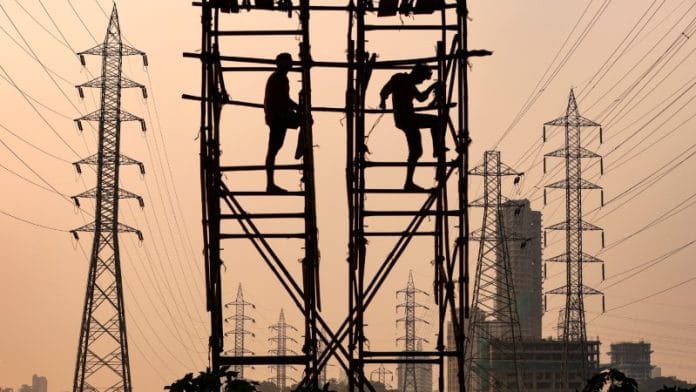 Labourers work next to electricity pylons in Mumbai | REUTERS/Francis Mascarenhas/File Photo