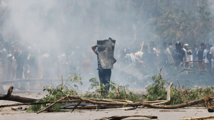 A protester covers himself with a metal sheet during a clash with Border Guard Bangladesh (BGB) and the police outside the state-owned Bangladesh Television as violence erupts across the country after anti-quota protests by students, in Dhaka, Bangladesh, 19 July, 2024 | Reuters/Mohammad Ponir Hossain/File Photo