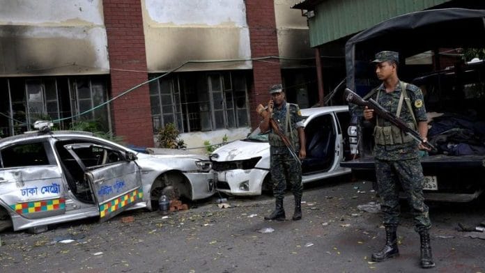 Security force personnel stand guard next to damaged vehicles outside a police station, days after the resignation of former Bangladeshi Prime Minister Sheikh Hasina, in Dhaka, Bangladesh, 8 August, 2024 | Reuters/Fatima Tuj Johora