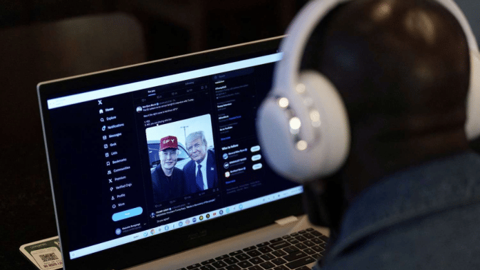 A person tries to watch on a laptop billionaire entrepreneur Elon Musk's interview with Republican presidential candidate and former U.S. President Donald Trump on the X social media network, in New York City, U.S. 12 August, 2024 | Reuters/Adam Gray