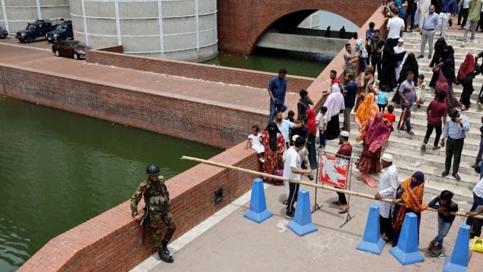 A member of the army stands guard as people gather at the entrance of the Parliament Building a day after the resignation of Bangladeshi Prime Minister Sheikh Hasina, in Dhaka, Bangladesh, August 6, 2024. REUTERS/Mohammad Ponir Hossain