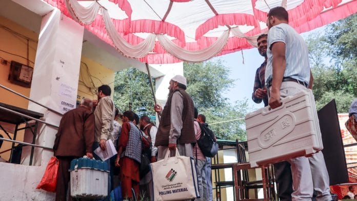 Polling officials carrying EVMs head toward their designated polling stations on the eve of the second phase of Jammu and Kashmir Assembly Polls, at Mendhar, in Poonch, 25 September