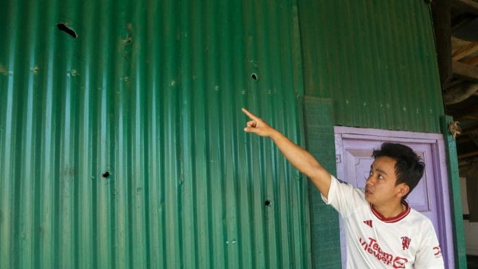 Mairembam Kelvin shows the holes in the tin shed in the compound of his late grandfather's house after a rocket bomb attack in Moirang, Manipur | Suraj Singh Bisht | ThePrint