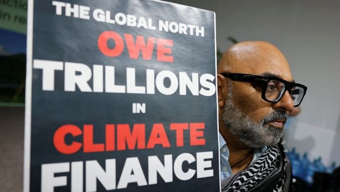 Representational image: An activist holds up a sign at a protest during COP29 in Baku, Azerbaijan | Reuters