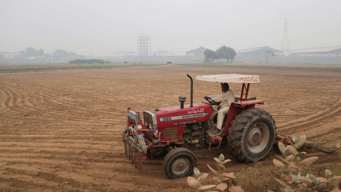 A farmer drives a tractor as he ploughs the ground on the outskirts of Lahore, Pakistan.| Representational image | Reuters