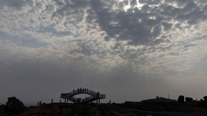 People stand on a viewing platform overlooking the Taiwan strait at the 68-nautical-mile scenic spot, one of mainland China's closest points to the island of Taiwan, on Pingtan Island, Fujian province, China, 8 April 2023. | Thomas Peter | Reuters